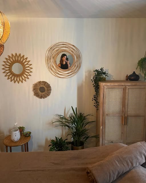 De spiegelwand met drie rotan spiegels boven de massagetafel